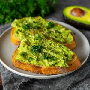 Creamy avocado toast topped with herbs and spices on whole grain bread