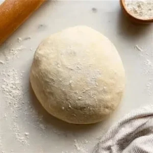 A bowl of easy homemade pizza dough ready for stretching and baking