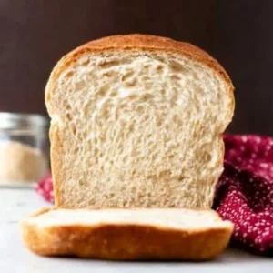 Freshly baked sandwich bread loaf on a wooden cutting board