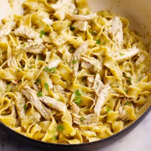 Comforting bowl of chicken and noodles with vegetables and herbs