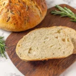 Loaf of freshly baked Rosemary Bread with herbs sprigs
