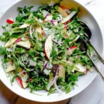 Arugula salad topped with sliced apples and parmesan cheese