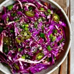 Colorful Asian slaw with vegetables and proteins in a bowl
