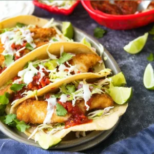 Delicious Baja Fish Tacos served with fresh toppings and lime.