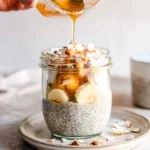 Chia pudding made with coconut milk served in a bowl, topped with fruits.