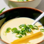 Fluffy Chinese steamed eggs served in a bowl, garnished with green onions.