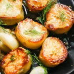 Deliciously roasted Fondant Potatoes served on a plate with herbs.