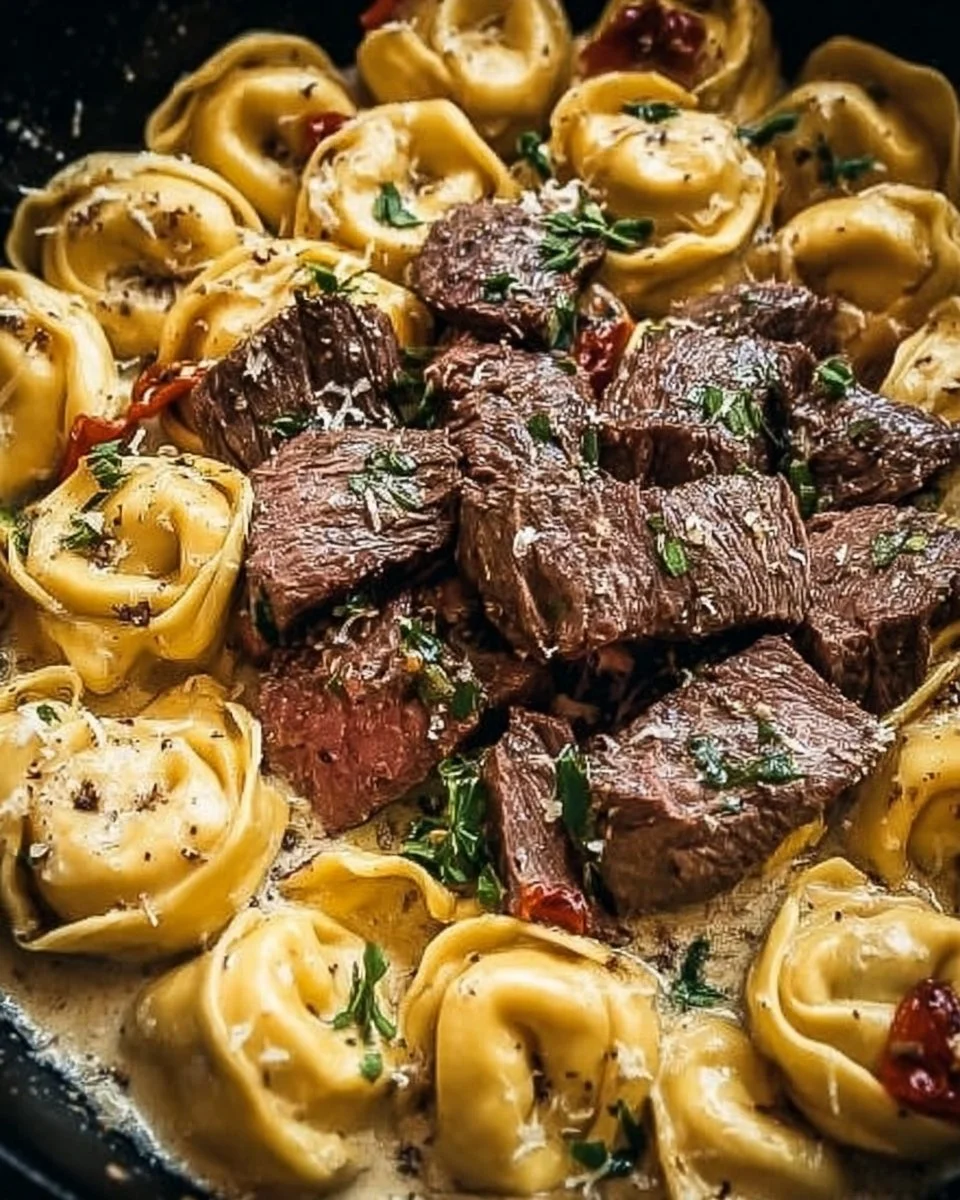 Creamy Garlic Steak Tortellini dish garnished with herbs and vegetables