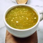 Homemade green enchilada sauce served in a bowl with cilantro garnish