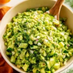 A vibrant Green Goddess Salad topped with fresh vegetables and creamy dressing.
