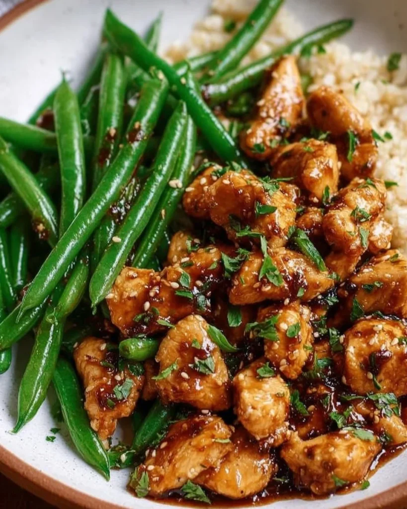 Delicious Honey Garlic Chicken served with green beans on a plate.