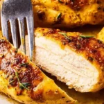 Juicy oven baked chicken breast served with fresh vegetables on a plate.