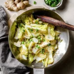 Sautéed Napa cabbage dish served in a bowl with a garnish