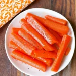 Bowl of simple steamed carrots garnished with herbs
