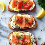 Smoked salmon with ricotta and egg toasts garnished with herbs on a plate