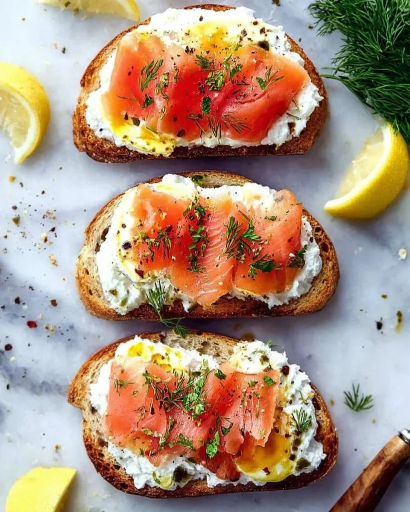 Smoked salmon with ricotta and egg toasts garnished with herbs on a plate