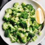 Steamed Lemon Garlic Broccoli served on a plate with lemon slices