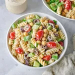 Bowl of Tahini Pasta Salad with fresh vegetables and herbs