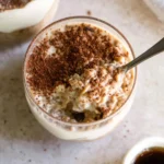 Delicious tiramisu overnight oats served in a mason jar with cocoa and coffee