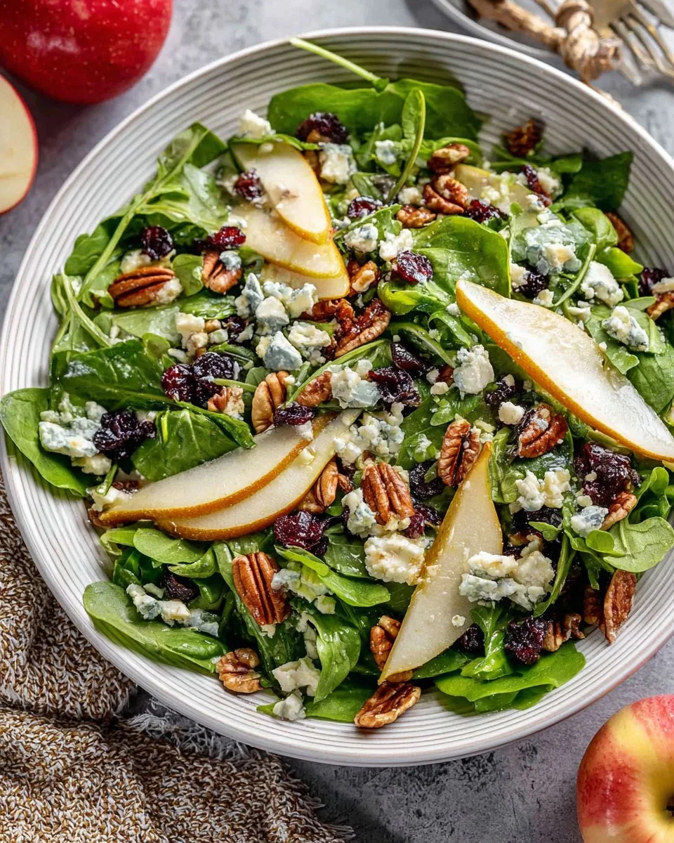 Fresh arugula pear salad with nuts and dressing garnished in a bowl