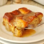 Heart-healthy bread pudding served in a bowl with a spoon, topped with fruit.
