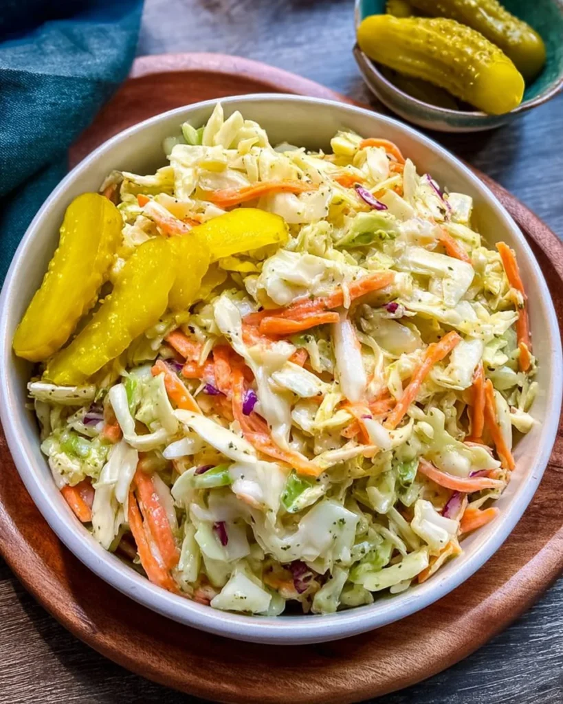 Bowl of delicious pickle coleslaw on a wooden table