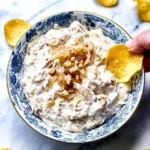 Creamy French onion dip served with fresh vegetables and chips.