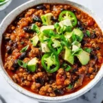 Delicious bowl of Ground Turkey Chili topped with fresh herbs and served with bread.
