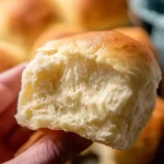 Freshly baked homemade mini slider rolls on a wooden cutting board