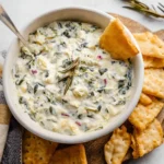 Healthy slow cooker spinach artichoke dip served in a bowl with tortilla chips