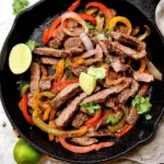 Delicious steak fajitas served with peppers and onions on a plate