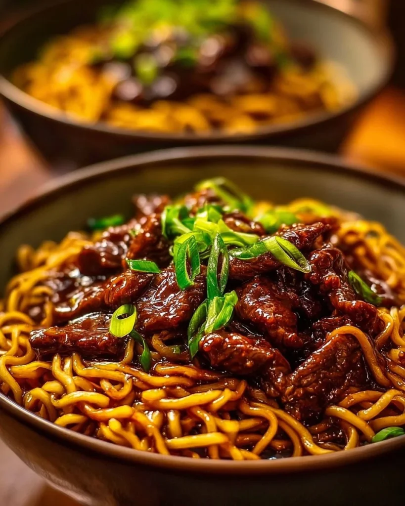 Sticky beef noodles served in a bowl with herbs and spices