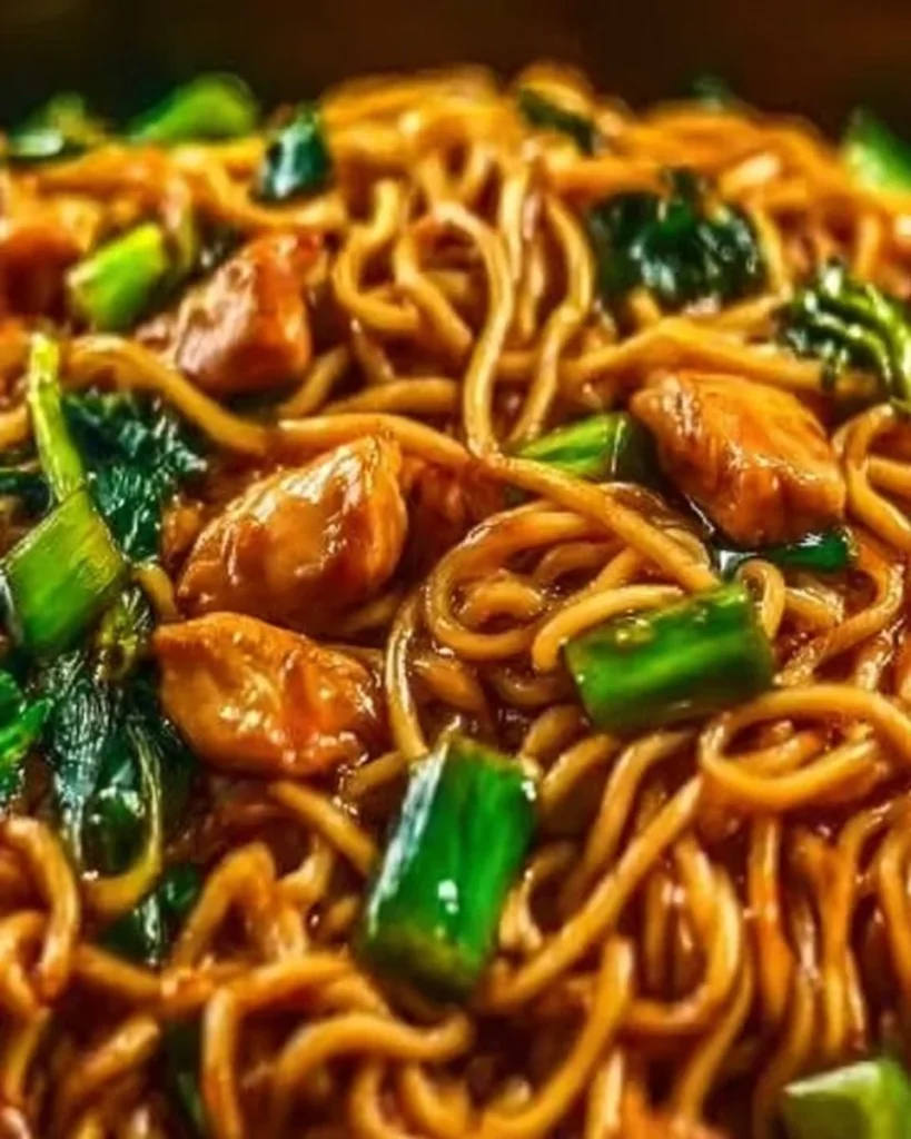 Sticky Garlic Chicken Noodles in a bowl garnished with herbs