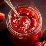 Homemade strawberry rhubarb sauce in a jar with fresh strawberries and rhubarb stalks