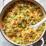Colorful bowl of Vegetable Fried Rice with fresh vegetables and herbs.