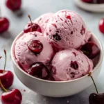Cherry Greek Yogurt served in a bowl with cherries and mint leaves