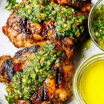 Grilled chimichurri chicken thighs garnished with fresh herbs and spices