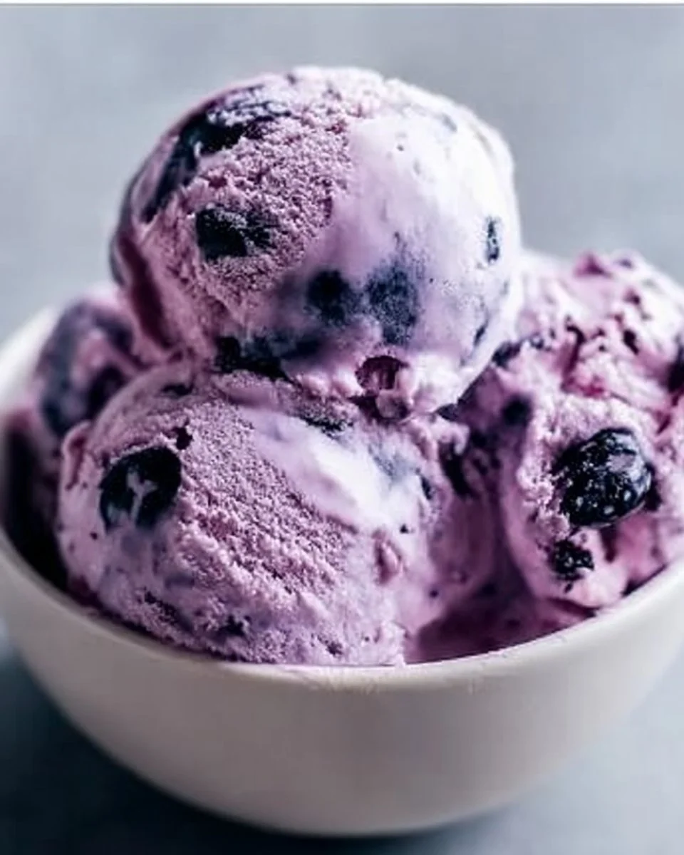 Creamy blueberry cottage cheese ice cream in a bowl with fresh blueberries