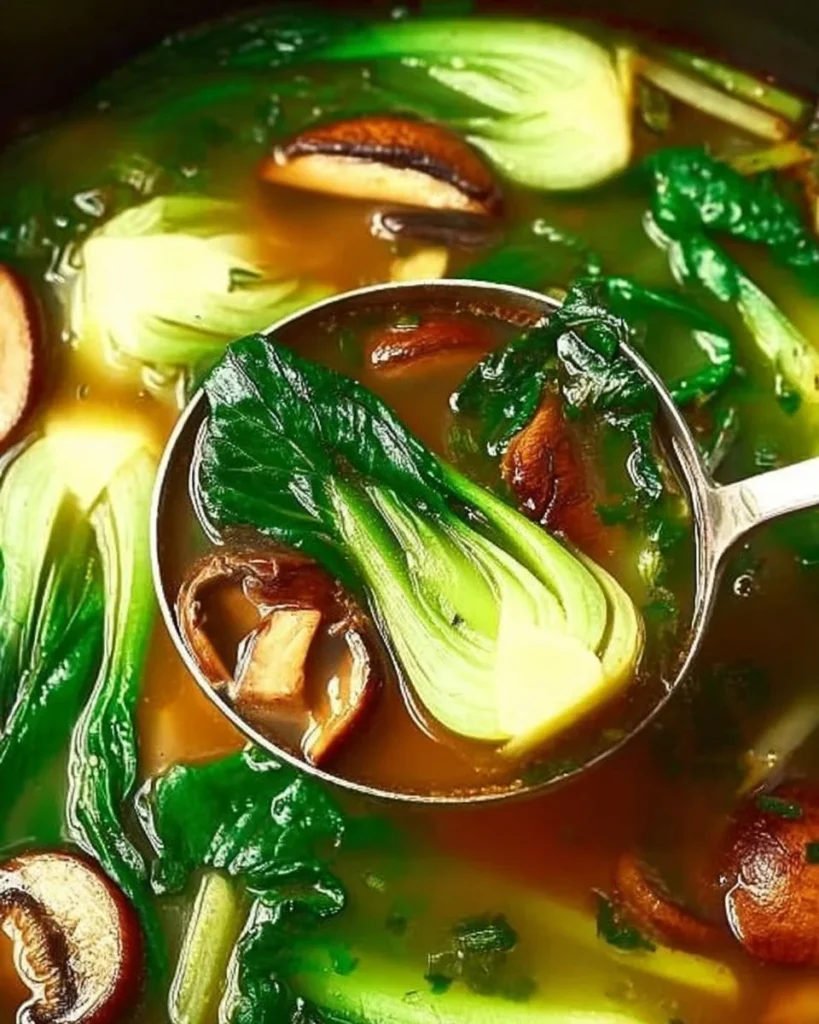 A bowl of homemade Bok Choy Soup garnished with green onions and herbs