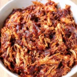 Oven-baked pulled chicken served with flavorful sides