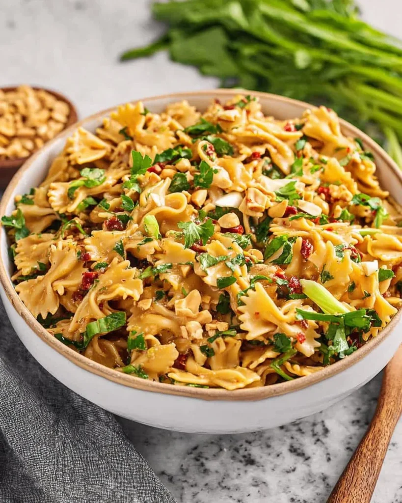 Spicy Thai Pasta Salad with fresh vegetables and zesty dressing served in a bowl.