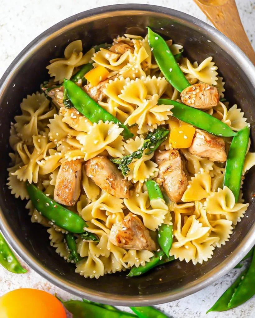 Plate of Teriyaki Chicken Pasta with fresh vegetables and sauce