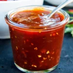 Delicious vegan barbecue sauce in a jar with fresh herbs and spices
