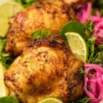 Golden brown air fryer chicken thighs served with fresh herbs and vegetables.