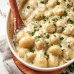 A bowl of creamy, savory creamed onions garnished with herbs.