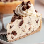 A slice of creamy no-bake cannoli cheesecake topped with chocolate chips and pistachios
