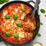 Delicious grilled eggplant parmesan topped with melted cheese and fresh basil.