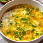 Bowl of homemade egg drop soup garnished with green onions