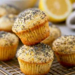 Freshly baked mini lemon poppy seed muffins on a cooling rack