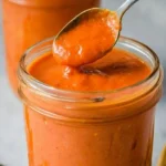 Homemade roasted cherry tomato sauce served in a bowl with fresh herbs